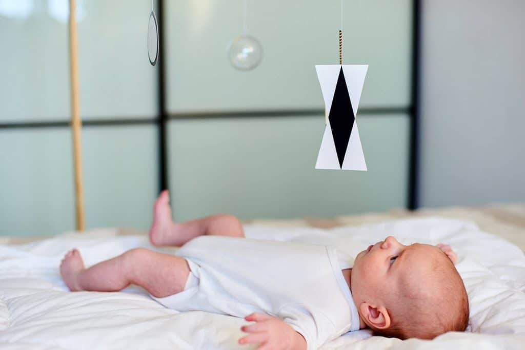 Baby looking at Montessori mobiles