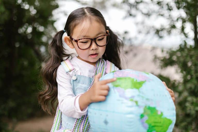 montessori elementary geography student using a globe