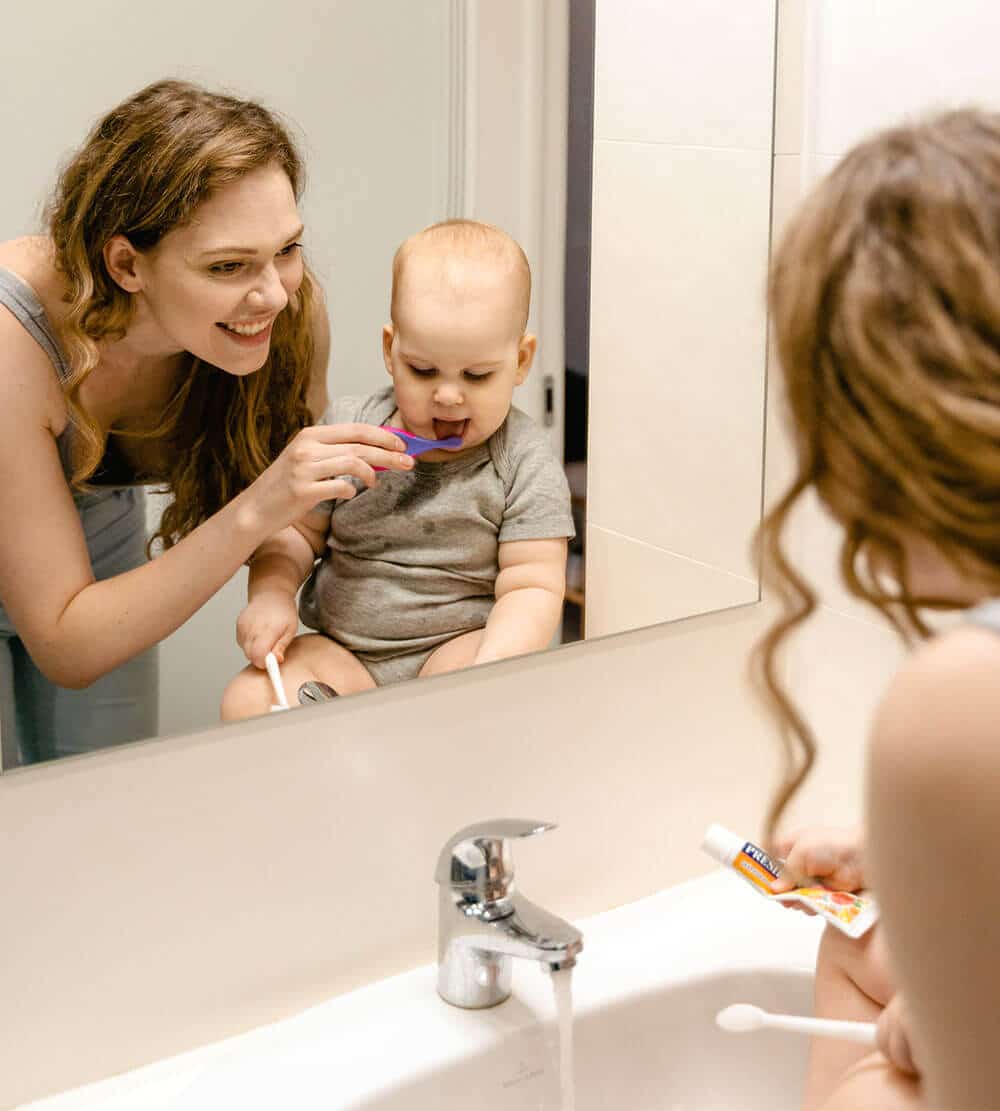 mom brushing her baby's teeth