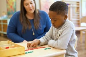 teacher and montessori guide helping student learn