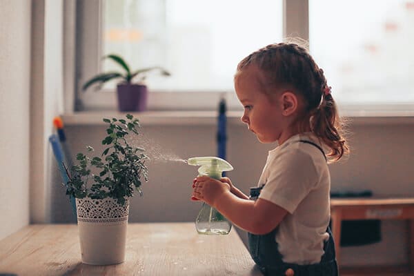 montessori child using her new found freedom to water a flower
